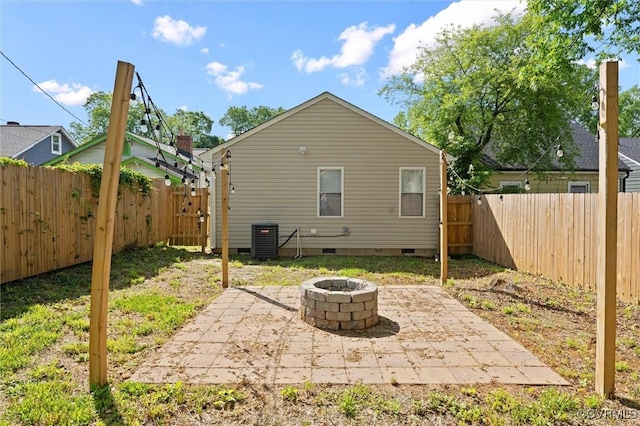 rear view of house with crawl space, an outdoor fire pit, cooling unit, a patio area, and a fenced backyard
