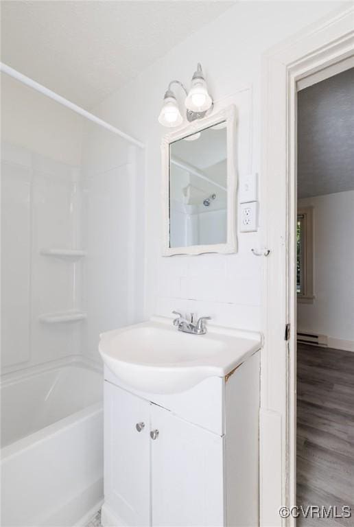 908 Rosemont Rd, Richmond, VA 23224 - full bathroom featuring baseboard heating, vanity, shower / tub combination, and wood finished floors