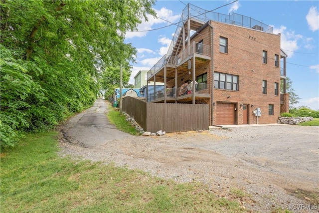 816 Riverside Park, Richmond, VA 23220 - view of side of home with dirt driveway, an attached garage, brick siding, and a balcony