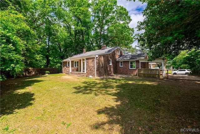 rear view of property featuring a chimney and brick siding