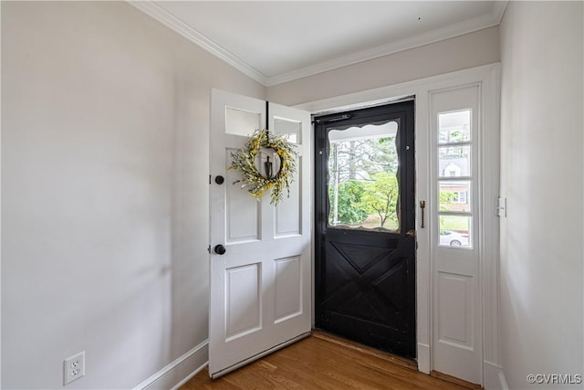 doorway featuring wood finished floors, ornamental molding, and baseboards
