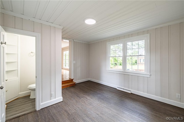 unfurnished bedroom with dark wood-style flooring, baseboards, ornamental molding, and ensuite bathroom