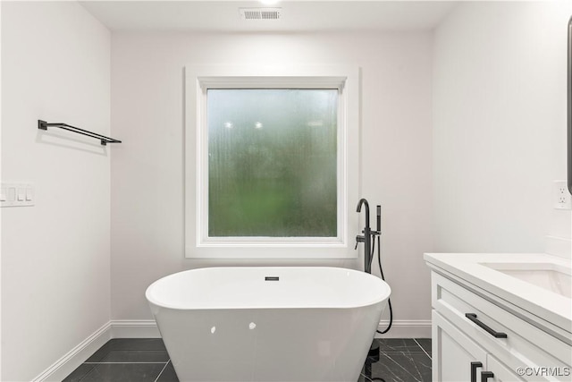 2809 Bethlehem Rd, Henrico, VA 23228 - full bathroom with baseboards, vanity, a freestanding tub, and marble look tile flooring
