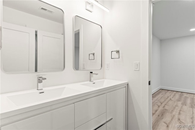 2809 Bethlehem Rd, Henrico, VA 23228 - full bathroom featuring wood finished floors, double vanity, and baseboards
