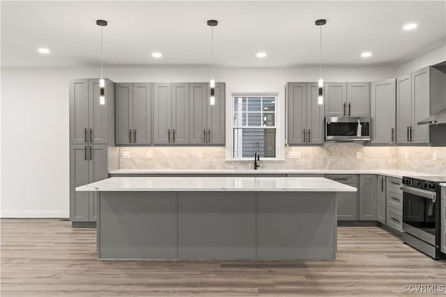 2809 Bethlehem Rd, Henrico, VA 23228 - kitchen with stainless steel appliances, gray cabinetry, a center island, light stone counters, and light wood-style flooring
