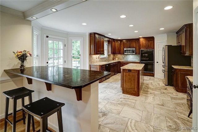 kitchen with black appliances, crown molding, a center island, recessed lighting, and tasteful backsplash