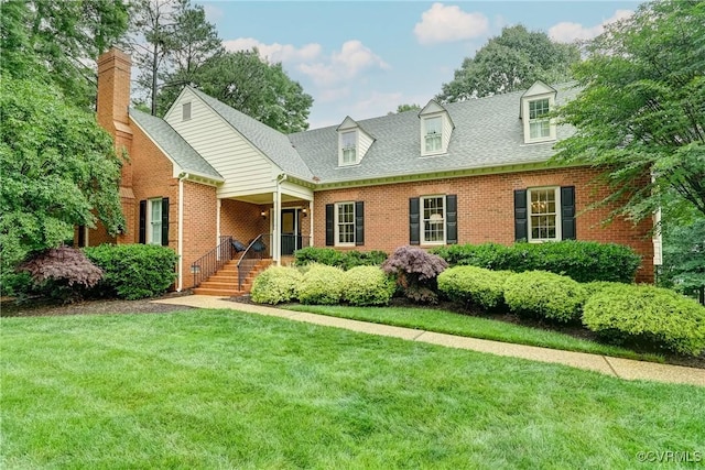 view of front of property featuring brick siding, a front lawn, a chimney, and a porch