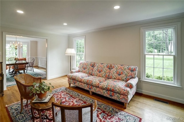living room with a chandelier, crown molding, plenty of natural light, light wood-style floors, and recessed lighting