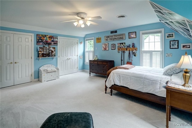 bedroom featuring two closets, carpet, and ceiling fan