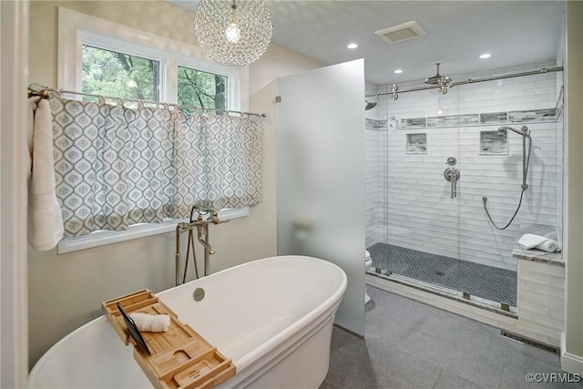 bathroom with a stall shower, a freestanding bath, and recessed lighting