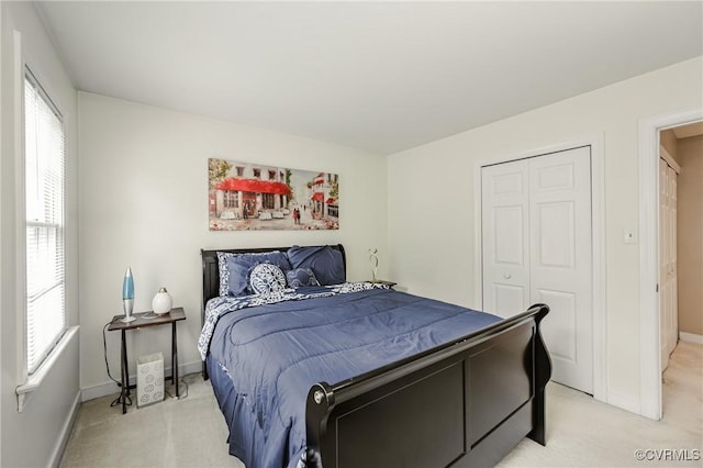 bedroom with light colored carpet, multiple windows, and a closet