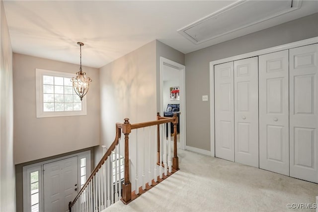 entrance foyer with carpet flooring, baseboards, and a chandelier