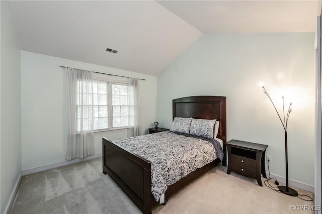 bedroom featuring light carpet, lofted ceiling, and baseboards