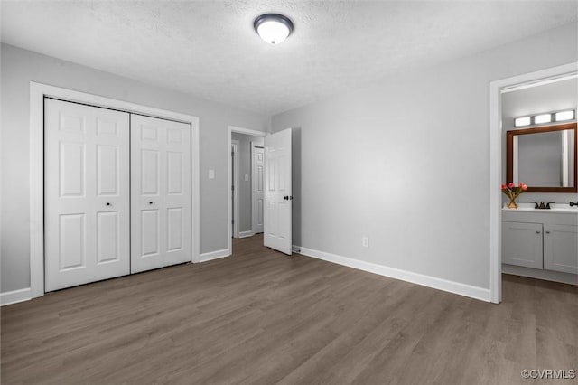 7408 Newbys Ct, Chesterfield, VA 23832 - unfurnished bedroom featuring wood finished floors, baseboards, a closet, connected bathroom, and a textured ceiling