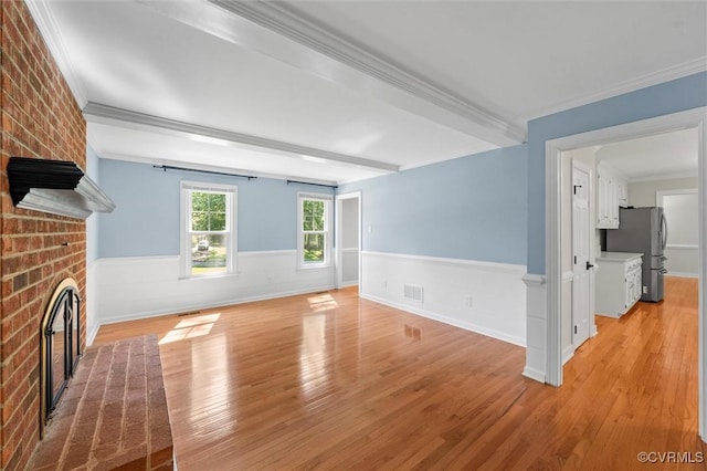 2430 Olde Stone Rd, Midlothian, VA 23113 - unfurnished living room featuring light wood-type flooring, wainscoting, a brick fireplace, and crown molding