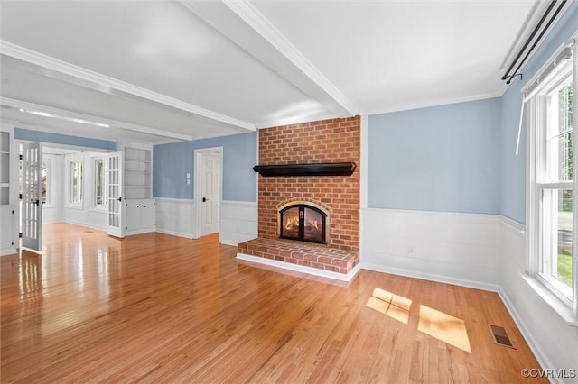 2430 Olde Stone Rd, Midlothian, VA 23113 - unfurnished living room featuring wood finished floors, a fireplace, plenty of natural light, a wainscoted wall, and crown molding