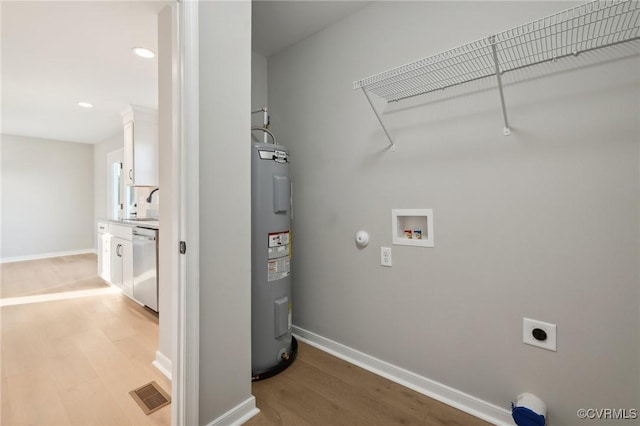 14057 Robinson Rd, Stony Creek, VA 23882 - washroom featuring hookup for a washing machine, electric dryer hookup, water heater, light wood finished floors, and baseboards