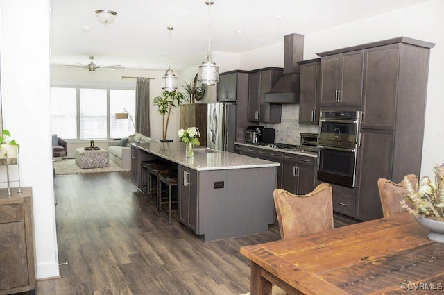 5112 Old Main St, Henrico, VA 23231 - kitchen featuring wall chimney exhaust hood, stainless steel appliances, a center island, backsplash, and dark brown cabinets