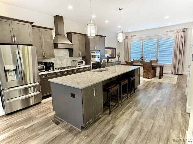 5112 Old Main St, Henrico, VA 23231 - kitchen featuring stainless steel appliances, custom range hood, an island with sink, a kitchen breakfast bar, and light wood-style flooring