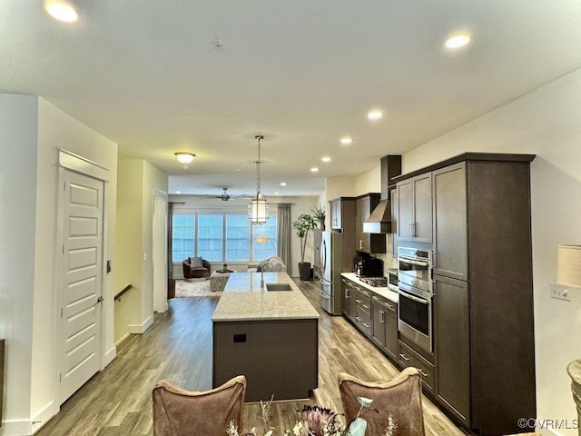 5112 Old Main St, Henrico, VA 23231 - kitchen featuring stainless steel appliances, light wood-style floors, an island with sink, open floor plan, and wall chimney exhaust hood