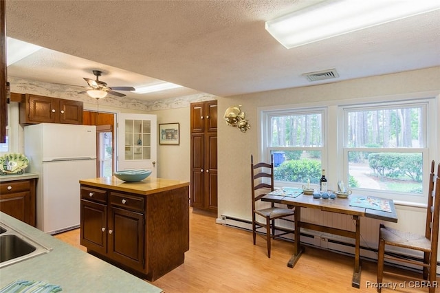 60 Edwards Landing Rd, Gwynn, VA 23066 - kitchen with freestanding refrigerator, a textured ceiling, ceiling fan, light wood-style flooring, and baseboard heating