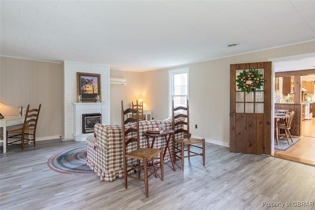 60 Edwards Landing Rd, Gwynn, VA 23066 - dining area featuring wood finished floors, a wall mounted AC, crown molding, baseboards, and a brick fireplace