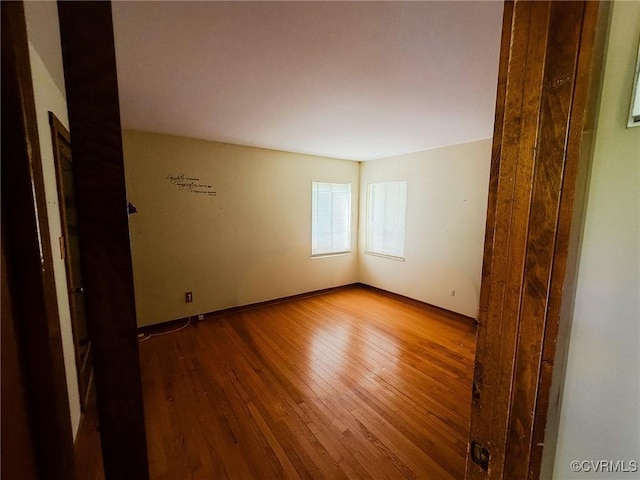 empty room featuring hardwood / wood-style floors and baseboards