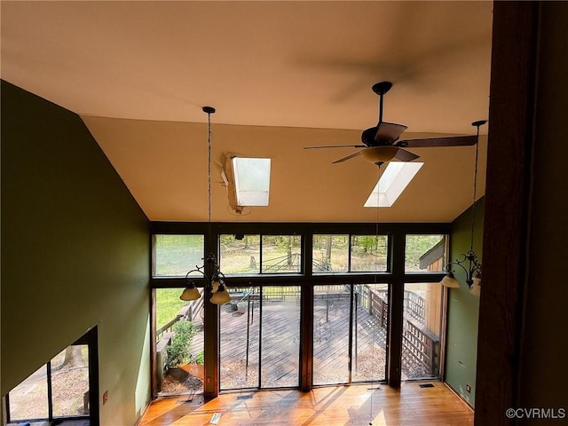 detailed view of a skylight, ceiling fan, and wood finished floors
