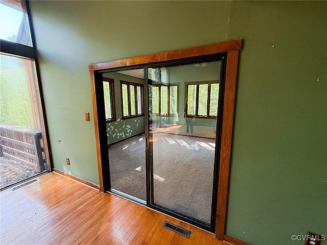 doorway with healthy amount of natural light, hardwood / wood-style flooring, and baseboards