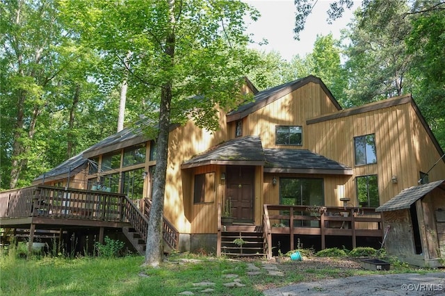 back of property featuring a wooden deck and stairway