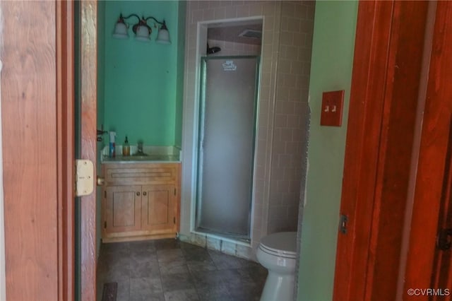 bathroom featuring a stall shower, toilet, tile patterned flooring, and vanity