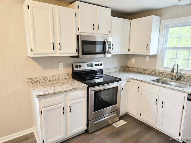 11400 Weyanoke Rd, Charles City, VA 23030 - kitchen with appliances with stainless steel finishes, dark wood-style flooring, white cabinets, and light stone countertops