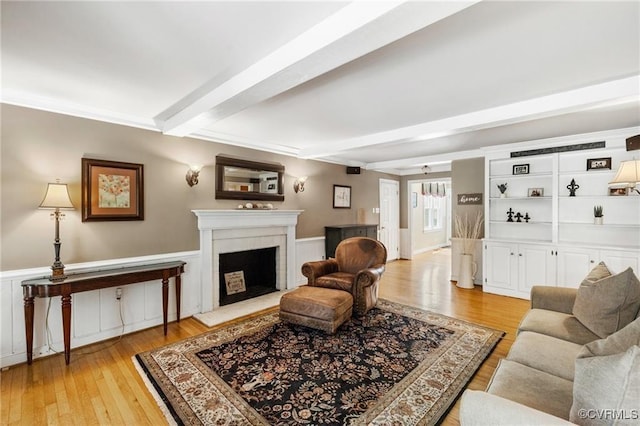 13951 Whitechapel Rd, Midlothian, VA 23113 - living area featuring beamed ceiling, light wood-type flooring, a fireplace, and a wainscoted wall