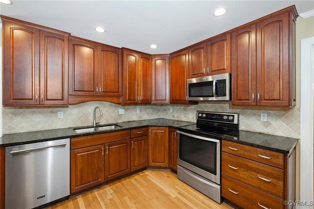 13951 Whitechapel Rd, Midlothian, VA 23113 - kitchen featuring appliances with stainless steel finishes, a sink, light wood-style flooring, dark stone countertops, and recessed lighting