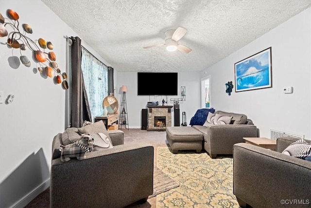 322 St Matthew St, Petersburg, VA 23803 - living area featuring a ceiling fan, carpet flooring, a fireplace, a textured ceiling, and baseboards