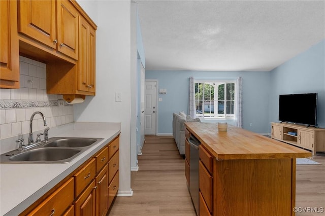 9120 Pepperidge Rd, Chesterfield, VA 23236 - kitchen with butcher block counters, open floor plan, a sink, light wood-style floors, and decorative backsplash