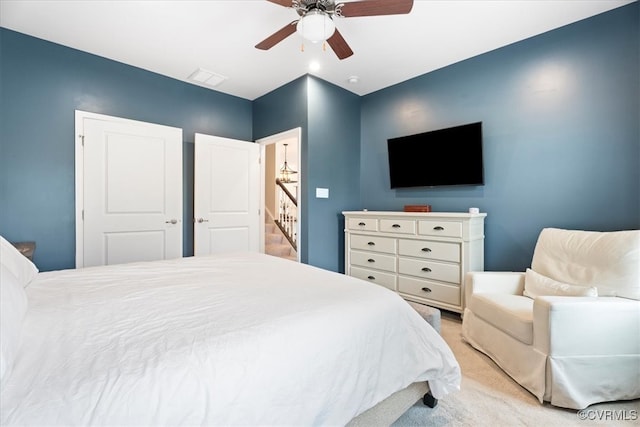 bedroom featuring light colored carpet and a ceiling fan