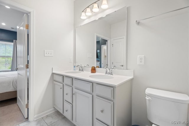 ensuite bathroom with baseboards, double vanity, toilet, and recessed lighting