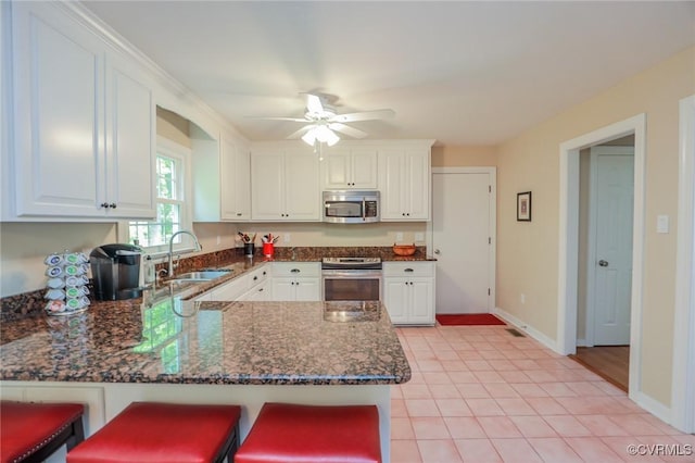 4606 Oak Hollow Rd, Chester, VA 23831 - kitchen with appliances with stainless steel finishes, a peninsula, white cabinets, and dark stone counters