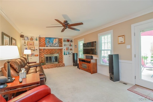 4606 Oak Hollow Rd, Chester, VA 23831 - living area featuring crown molding, ceiling fan, built in features, a wainscoted wall, and a fireplace