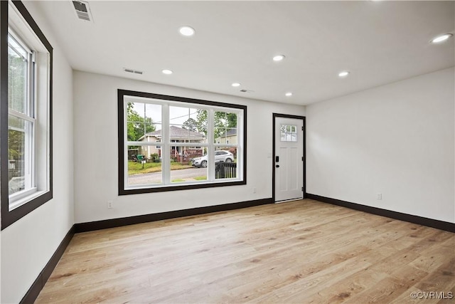spare room featuring recessed lighting, light wood-style flooring, and baseboards