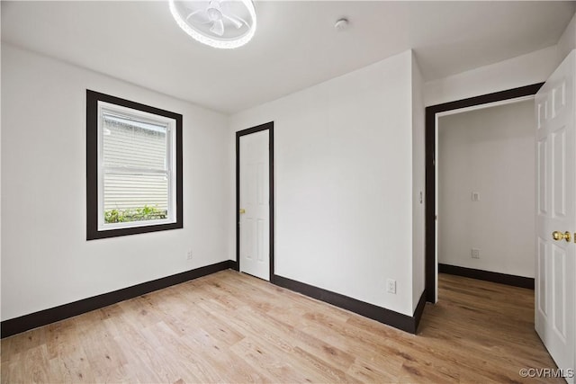 unfurnished bedroom featuring light wood-style flooring and baseboards