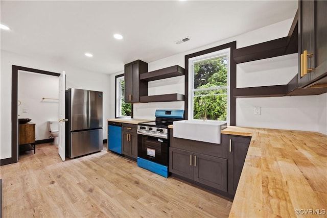 kitchen featuring open shelves, appliances with stainless steel finishes, wood counters, light wood-style floors, and recessed lighting