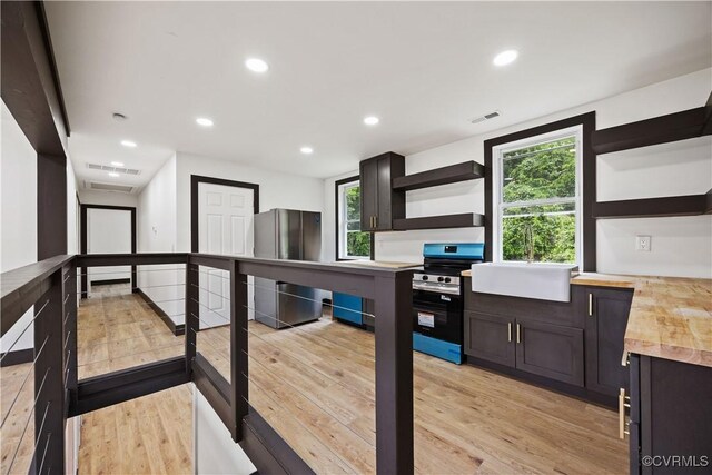interior space featuring open shelves, refrigerator, stainless steel electric range oven, light wood-type flooring, and recessed lighting