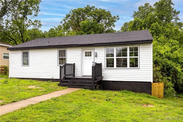 view of front facade featuring a front lawn and a shingled roof