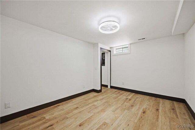 unfurnished room with baseboards and light wood-style floors