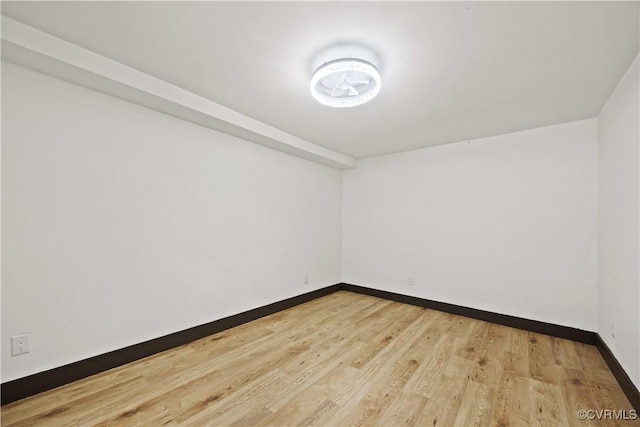 unfurnished room with baseboards and light wood-style flooring