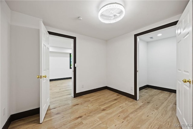 unfurnished bedroom featuring light wood finished floors and baseboards