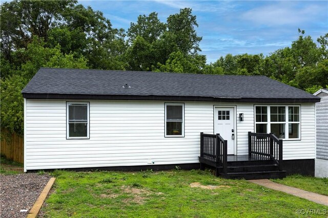 view of front of home with a front lawn and a shingled roof