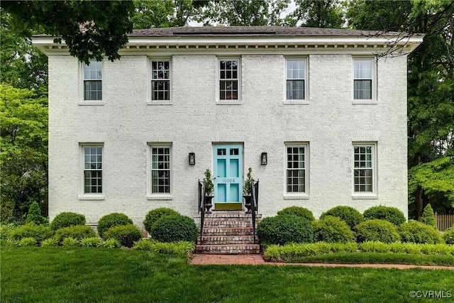 colonial-style house with a front lawn